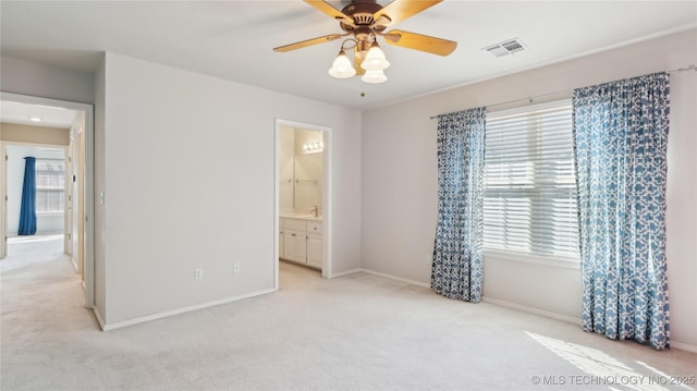 unfurnished bedroom with visible vents, baseboards, ceiling fan, light colored carpet, and ensuite bathroom