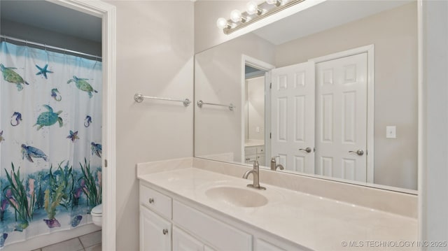 full bathroom with tile patterned floors, curtained shower, toilet, and vanity