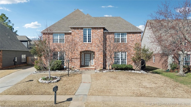 view of front of house featuring brick siding and a shingled roof