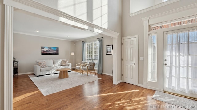 foyer with baseboards, wood finished floors, and crown molding