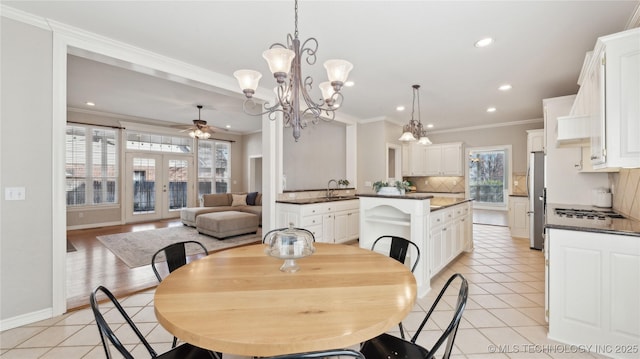 dining room featuring light tile patterned floors, french doors, and crown molding