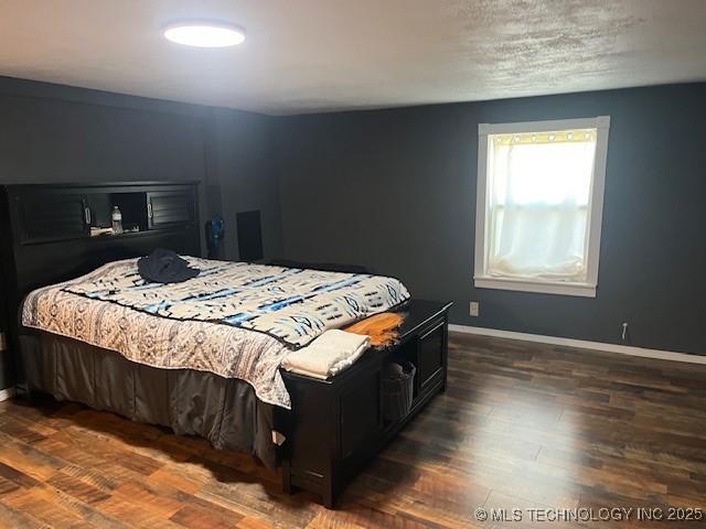 bedroom featuring wood finished floors and baseboards