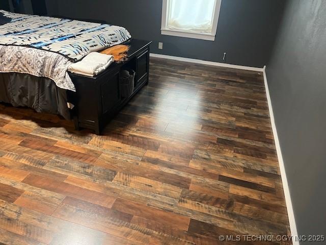 bedroom featuring baseboards and dark wood finished floors