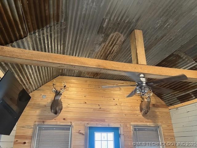room details with a ceiling fan and wood walls