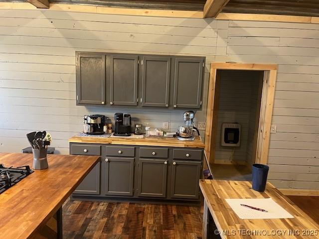 kitchen featuring wooden walls, dark wood-type flooring, butcher block counters, gray cabinets, and heating unit