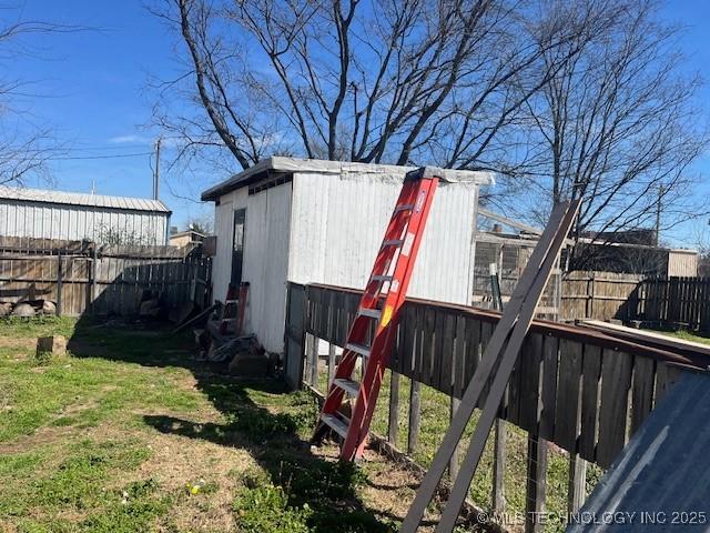 view of outdoor structure with a fenced backyard and an outdoor structure