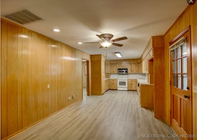 kitchen with visible vents, light countertops, electric stove, stainless steel microwave, and light wood-type flooring