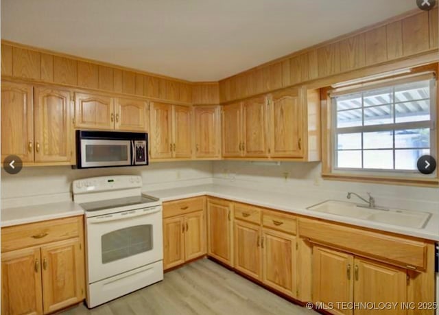 kitchen featuring stainless steel microwave, light countertops, white electric range, and a sink