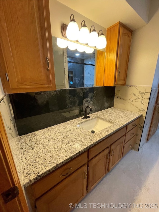 full bath featuring backsplash, vanity, and a shower