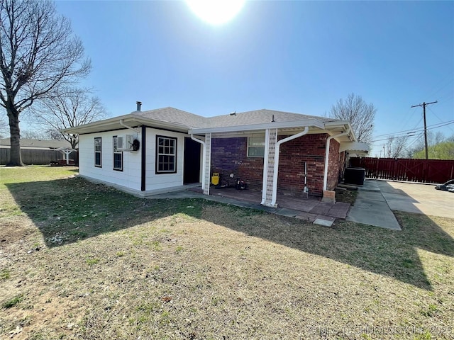 back of house featuring a shingled roof, fence, cooling unit, a yard, and a patio area