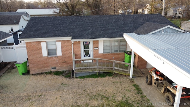 view of front of property with crawl space, brick siding, roof with shingles, and fence