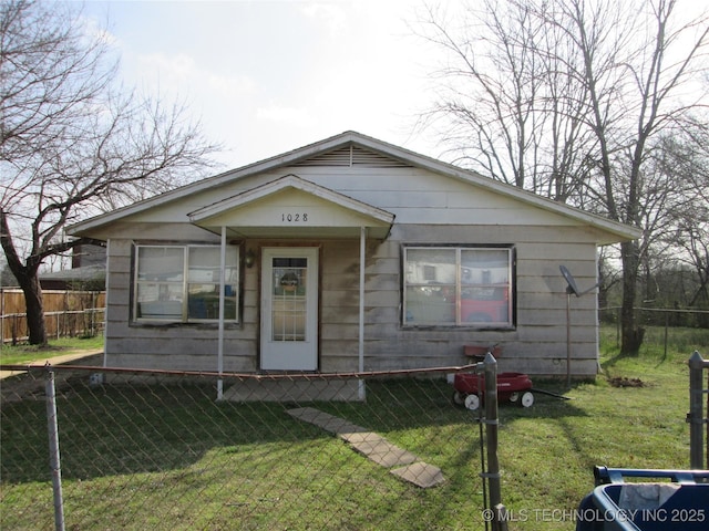 bungalow-style house featuring a fenced front yard and a front lawn