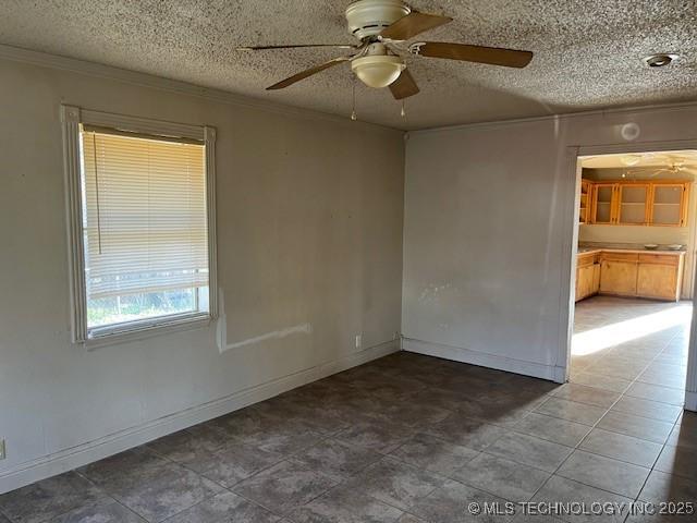 unfurnished room with a textured ceiling, ceiling fan, baseboards, and ornamental molding