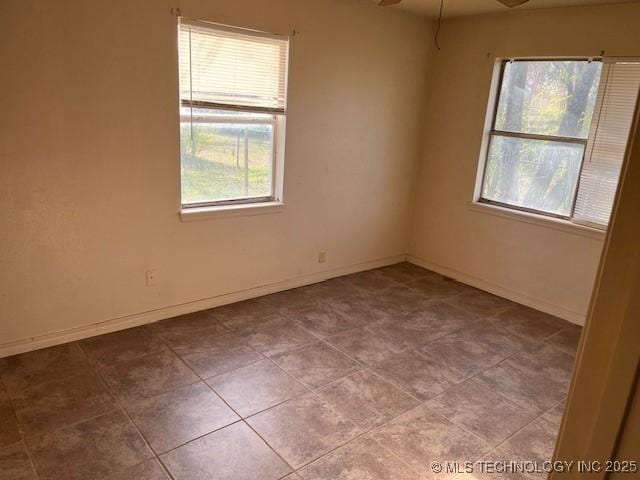 unfurnished room featuring baseboards and ceiling fan