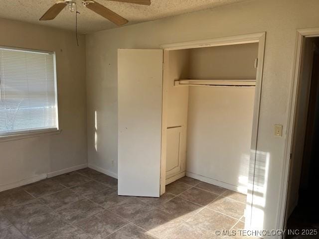 unfurnished bedroom with baseboards, a closet, ceiling fan, and a textured ceiling