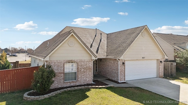 view of front facade featuring brick siding, fence, roof with shingles, driveway, and an attached garage