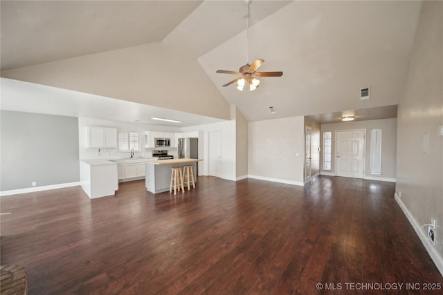 unfurnished living room with baseboards, high vaulted ceiling, ceiling fan, and dark wood-style flooring