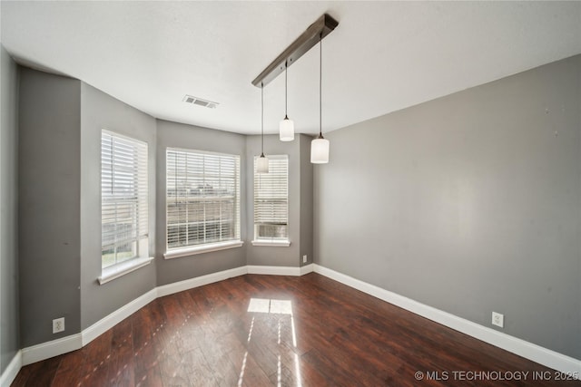 unfurnished dining area with visible vents, baseboards, and wood finished floors