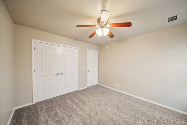 unfurnished bedroom featuring visible vents, baseboards, a closet, and carpet flooring