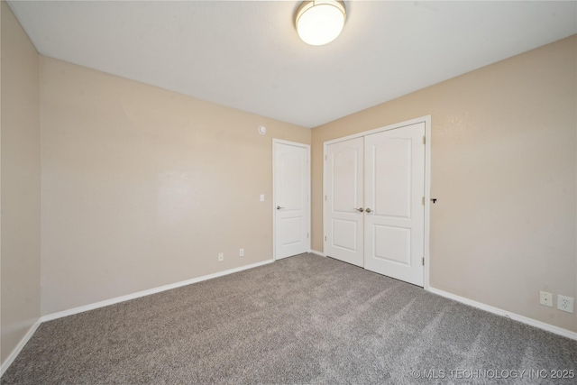 unfurnished bedroom featuring baseboards, a closet, and carpet floors