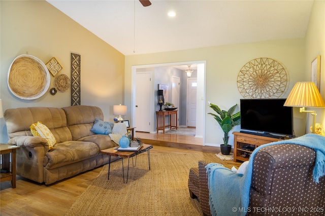 living room with lofted ceiling, wood finished floors, baseboards, and ceiling fan