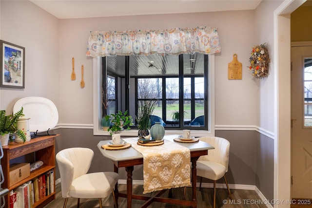 dining space featuring wood finished floors and baseboards