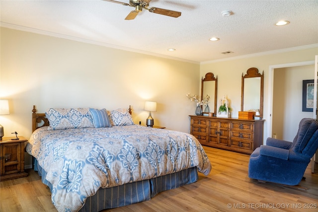 bedroom with a ceiling fan, wood finished floors, visible vents, ornamental molding, and a textured ceiling