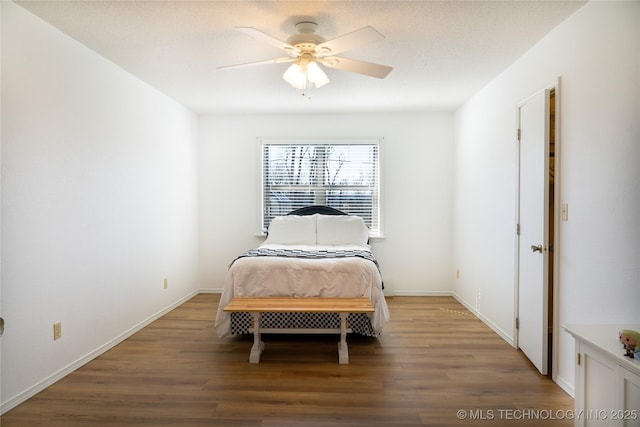 bedroom featuring ceiling fan, a textured ceiling, baseboards, and wood finished floors