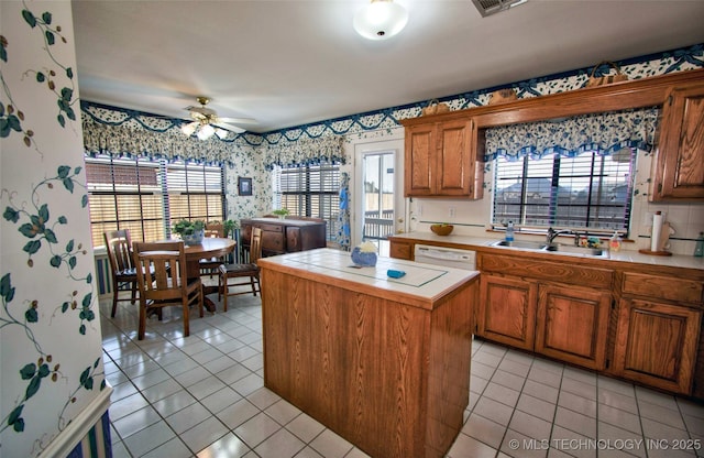 kitchen featuring ceiling fan, plenty of natural light, tile counters, and wallpapered walls