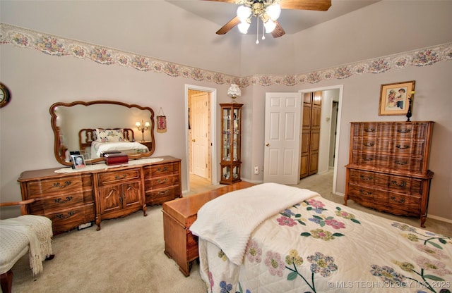 bedroom featuring light carpet, ensuite bath, and ceiling fan