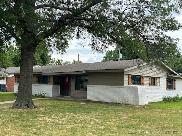 ranch-style house featuring a front lawn, brick siding, and a shingled roof