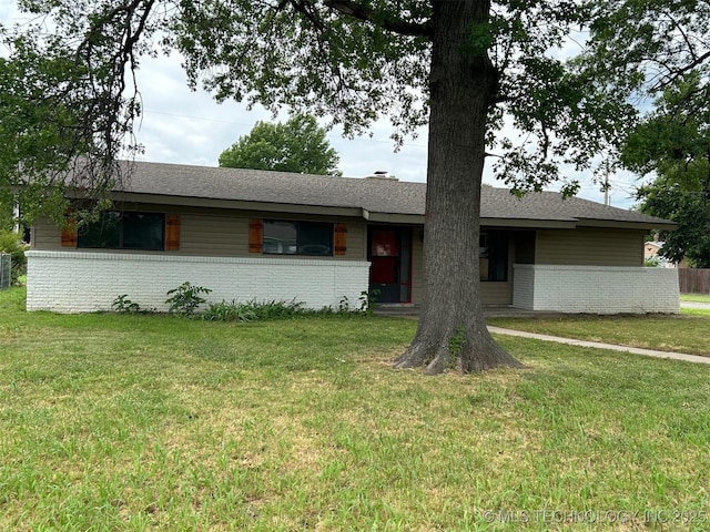 ranch-style home with a front lawn, brick siding, and roof with shingles