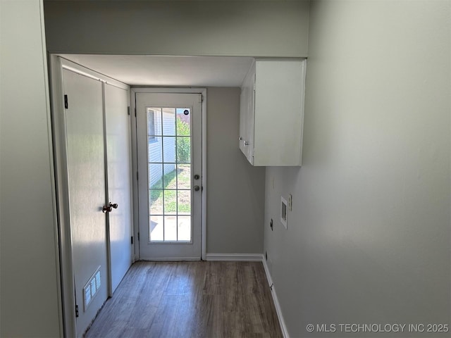 doorway to outside with visible vents, baseboards, and wood finished floors