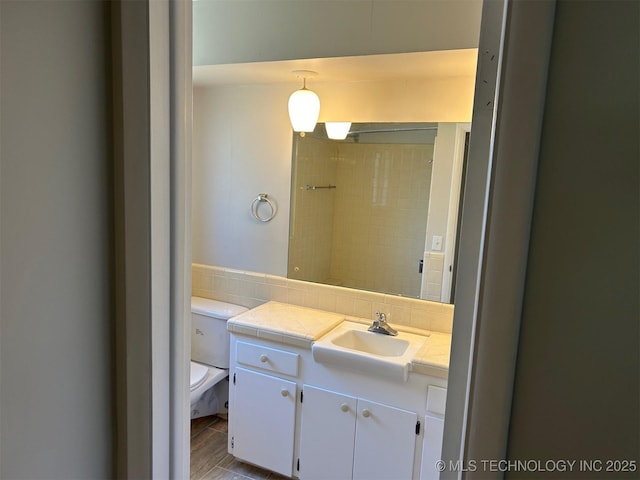 bathroom featuring decorative backsplash, toilet, and vanity