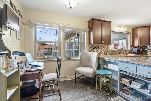 kitchen with tasteful backsplash, crown molding, light stone countertops, dark wood finished floors, and a sink