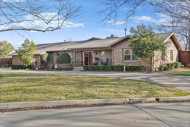 ranch-style house with a front lawn, fence, and stone siding