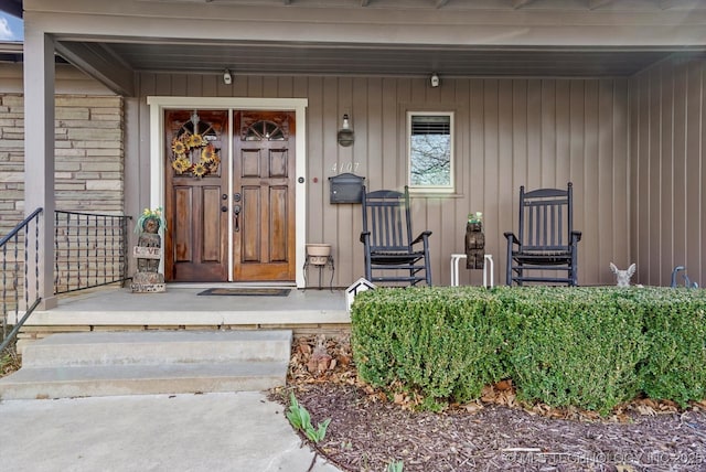 view of exterior entry featuring a porch and board and batten siding