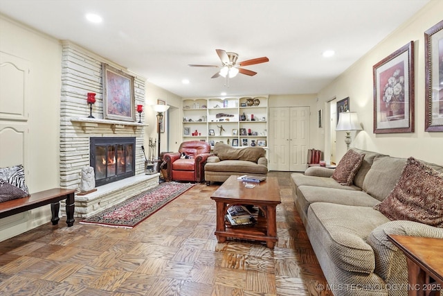 living room with recessed lighting, a large fireplace, built in features, and ceiling fan