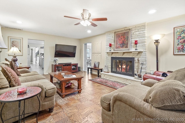 living room featuring a stone fireplace, recessed lighting, baseboards, and a ceiling fan