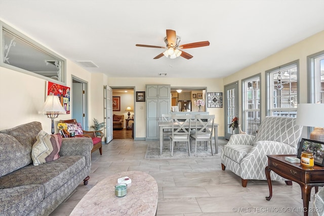 living room featuring visible vents and a ceiling fan