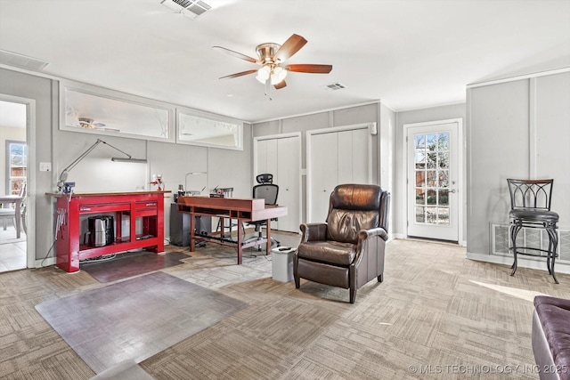 sitting room with visible vents, carpet floors, baseboards, and a ceiling fan