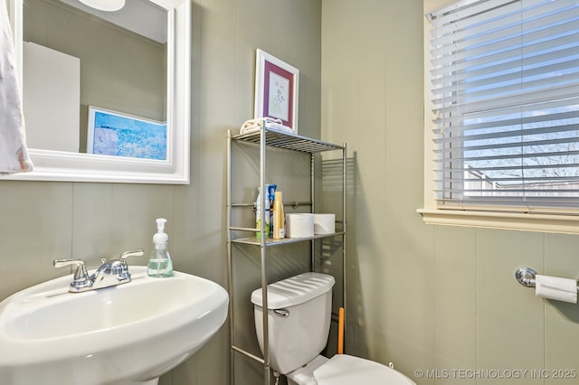 half bathroom featuring toilet and a sink