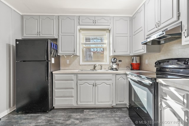 kitchen with a sink, black appliances, light countertops, dark wood-type flooring, and under cabinet range hood