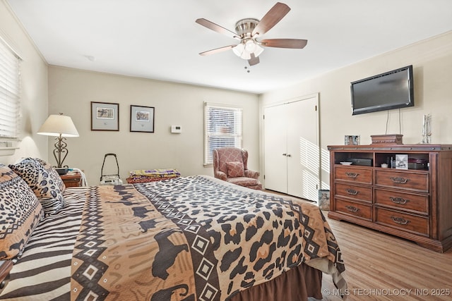 bedroom featuring a closet, light wood-style flooring, and a ceiling fan