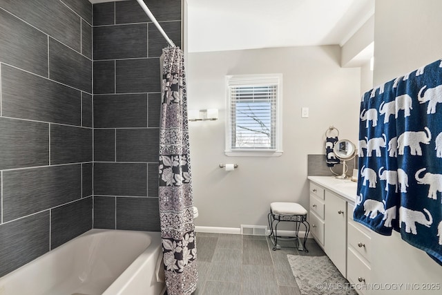 full bathroom featuring visible vents, vanity, shower / bath combo with shower curtain, and baseboards