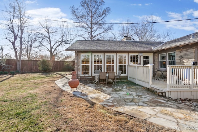 exterior space featuring a wooden deck, a patio, and fence