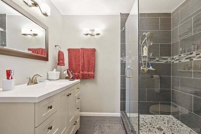 bathroom featuring ornamental molding, a shower stall, tile patterned flooring, baseboards, and vanity