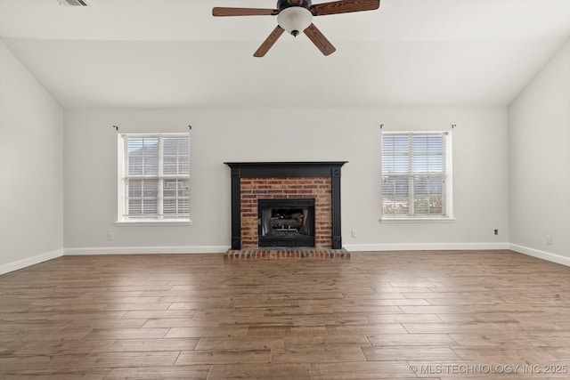 unfurnished living room featuring plenty of natural light, wood finished floors, a ceiling fan, and vaulted ceiling