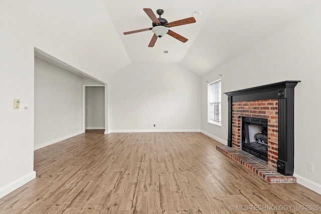 unfurnished living room with wood finished floors, a ceiling fan, baseboards, lofted ceiling, and a brick fireplace