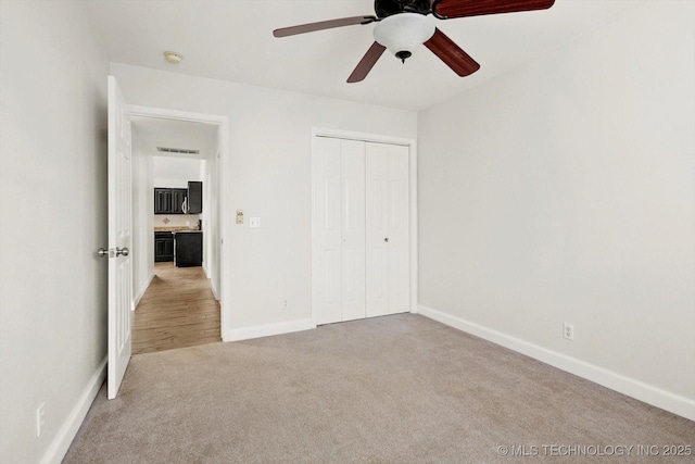 unfurnished bedroom with visible vents, baseboards, carpet floors, ceiling fan, and a closet